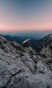 Preview wallpaper building, mountains, peaks, distance, sunset, stone