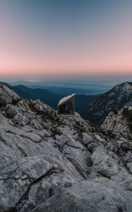 Preview wallpaper building, mountains, peaks, distance, sunset, stone