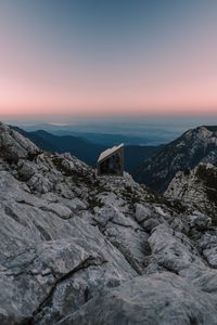 Preview wallpaper building, mountains, peaks, distance, sunset, stone