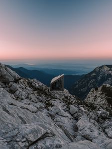 Preview wallpaper building, mountains, peaks, distance, sunset, stone