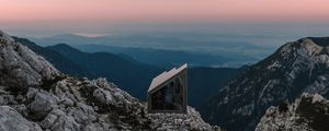 Preview wallpaper building, mountains, peaks, distance, sunset, stone