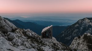 Preview wallpaper building, mountains, peaks, distance, sunset, stone