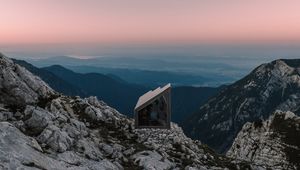 Preview wallpaper building, mountains, peaks, distance, sunset, stone