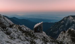 Preview wallpaper building, mountains, peaks, distance, sunset, stone