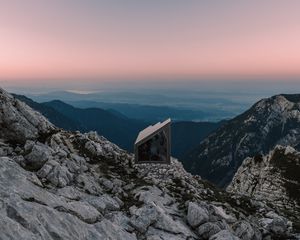 Preview wallpaper building, mountains, peaks, distance, sunset, stone