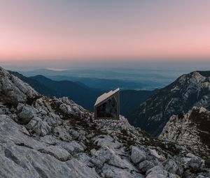 Preview wallpaper building, mountains, peaks, distance, sunset, stone