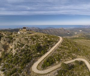 Preview wallpaper building, mountains, road, turn, aerial view