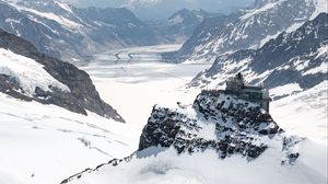 Preview wallpaper building, mountains, rocks, snow, winter