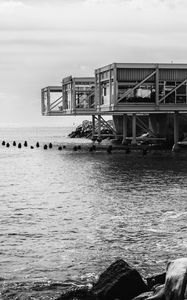 Preview wallpaper building, pilings, architecture, sea, black and white