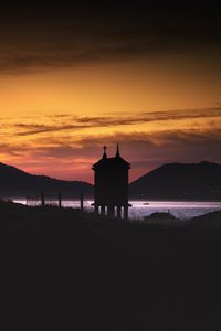 Preview wallpaper building, pilings, lake, mountains, silhouettes, evening