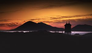 Preview wallpaper building, pilings, lake, mountains, silhouettes, evening