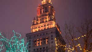 Preview wallpaper building, tower, architecture, trees, garlands, dark