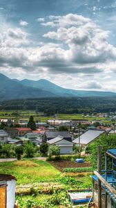 Preview wallpaper building, village, grass, sky, mountains