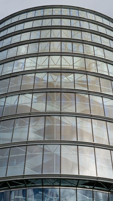 360x640 Wallpaper building, windows, walls, clouds, city, architecture
