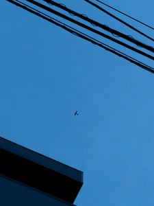 Preview wallpaper building, wires, airplane, sky