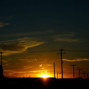 Preview wallpaper buildings, antennas, sun, sunset, clouds, sky, dark