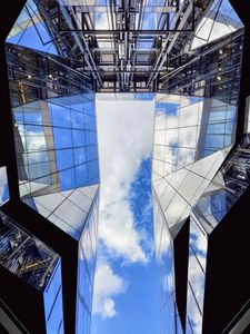 Preview wallpaper buildings, bottom view, mirror, sky, clouds, architecture