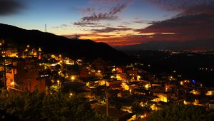 Preview wallpaper buildings, city, lights, hills, silhouettes, evening