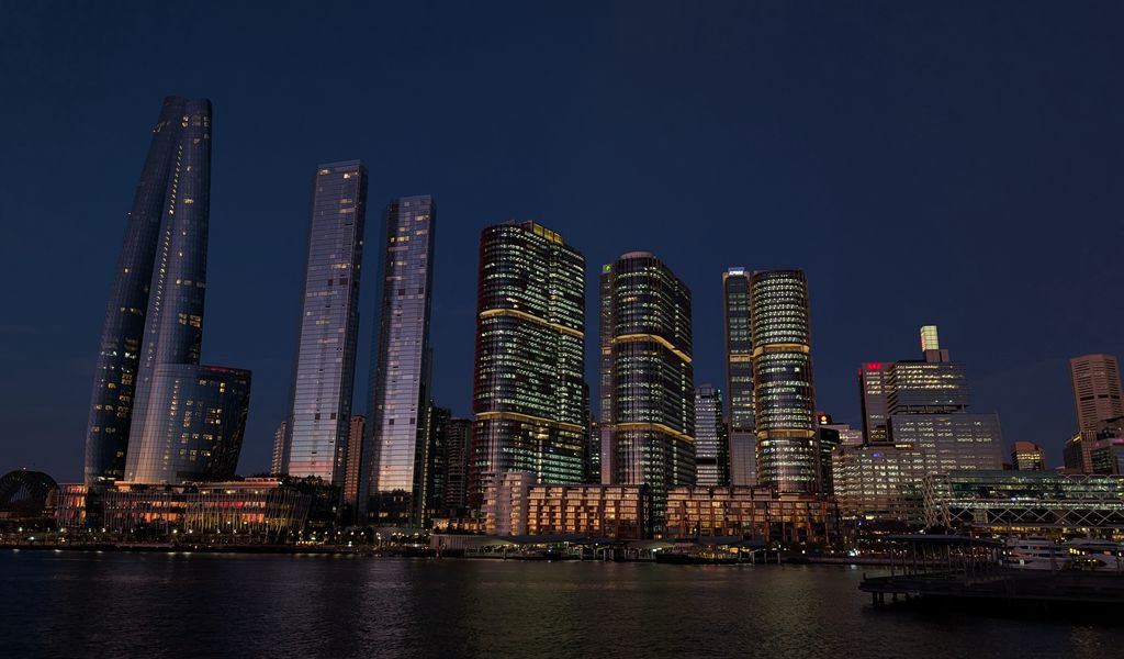 1024x600 Wallpaper buildings, city, river, bridge, evening, night, dark