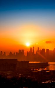 Preview wallpaper buildings, city, sun, sunset, silhouettes, river