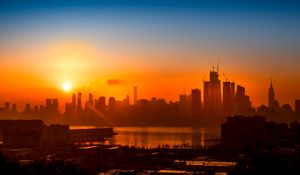 Preview wallpaper buildings, city, sun, sunset, silhouettes, river
