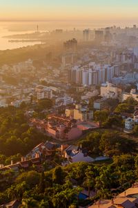 Preview wallpaper buildings, city, trees, sea, dawn, aerial view