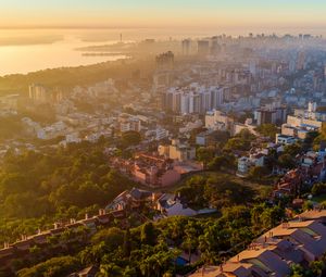 Preview wallpaper buildings, city, trees, sea, dawn, aerial view