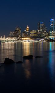 Preview wallpaper buildings, lights, river, reflection, stones, night, city