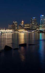 Preview wallpaper buildings, lights, river, reflection, stones, night, city