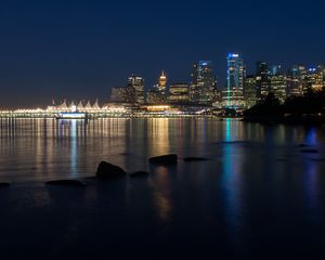 Preview wallpaper buildings, lights, river, reflection, stones, night, city