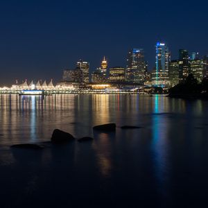 Preview wallpaper buildings, lights, river, reflection, stones, night, city