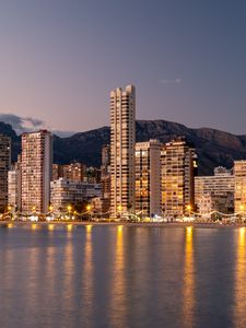 Preview wallpaper buildings, lights, sea, mountains, city, twilight