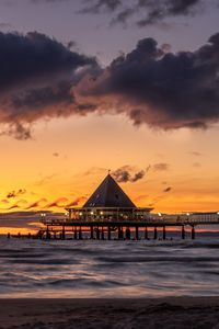 Preview wallpaper bungalow, pier, sunset, sea, sky