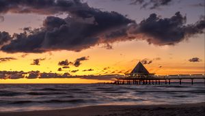 Preview wallpaper bungalow, pier, sunset, sea, sky