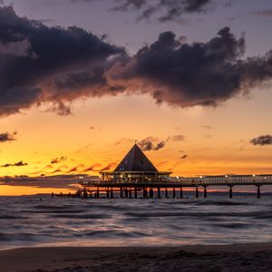 Preview wallpaper bungalow, pier, sunset, sea, sky