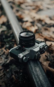 Preview wallpaper camera, gray, rail, fallen leaves