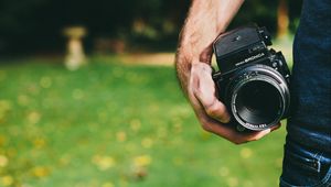 Preview wallpaper camera, hand, lens, optics, black