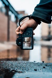 Preview wallpaper camera, hand, photo, puddle, building