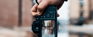 Preview wallpaper camera, hand, photo, puddle, building