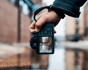 Preview wallpaper camera, hand, photo, puddle, building