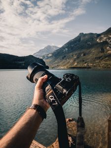 Preview wallpaper camera, lens, hand, mountains, focus