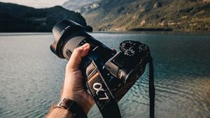 Preview wallpaper camera, lens, hand, mountains, focus