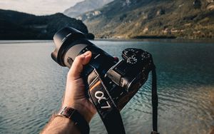Preview wallpaper camera, lens, hand, mountains, focus
