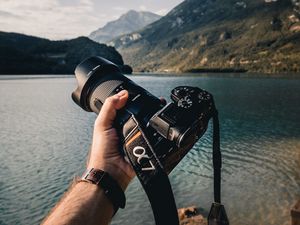 Preview wallpaper camera, lens, hand, mountains, focus
