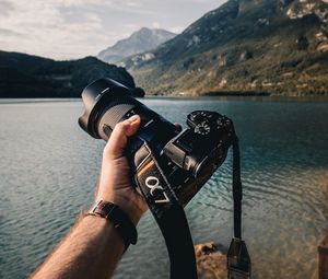 Preview wallpaper camera, lens, hand, mountains, focus