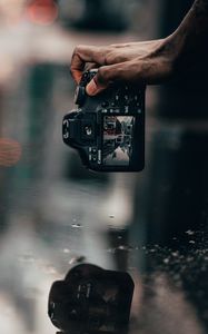 Preview wallpaper camera, snapshot, puddle, hand, reflection