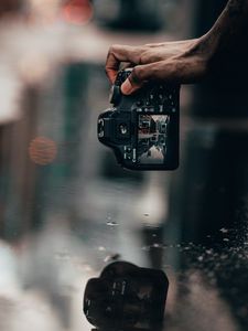 Preview wallpaper camera, snapshot, puddle, hand, reflection