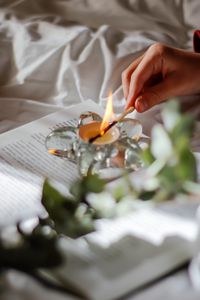 Preview wallpaper candle, match, hand, book, branch