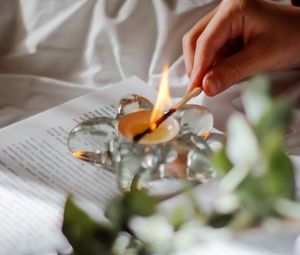 Preview wallpaper candle, match, hand, book, branch