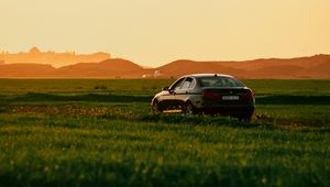 Preview wallpaper car, black, field, sunset